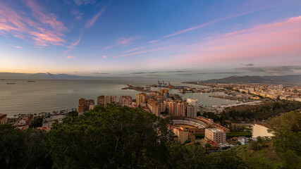 Obraz premium Panoramic City Harbor With Ocean Bay, Docks, and Mountain Range at Sunset in Malaga, Spain