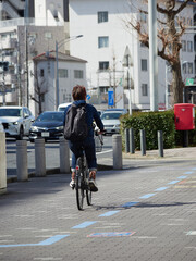 Fototapeta premium 春の昼の名古屋の街で自転車を乗る男性と町並みの風景