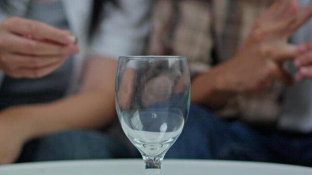 Conceptual shot of husband and wife discarding rings into glass during legal separation or divorce