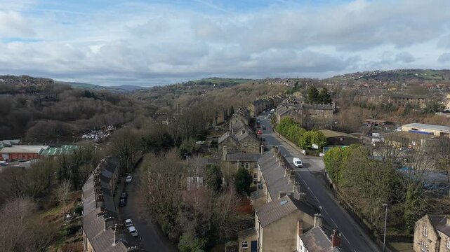Drone shot of a British mill town landscape with historic stone architecture and rolling hills.