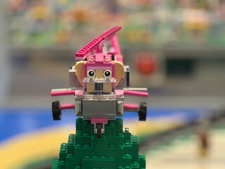 Naklejka premium Pink brick airplane on green stand