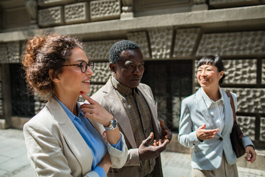 Business colleagues walking and talking on city street