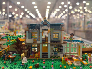 Naklejka premium Colorful two-story lego house with garden and minifigures