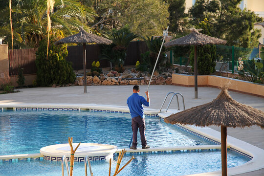 Socorrista en mantenimiento y limpieza de piscina en verano