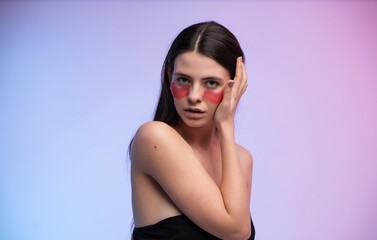 Naklejka premium Woman applying pink eye patches for under eye zone treatment, focusing on skincare and beauty routine, performing self care for healthy skin, promoting wellness and hydration