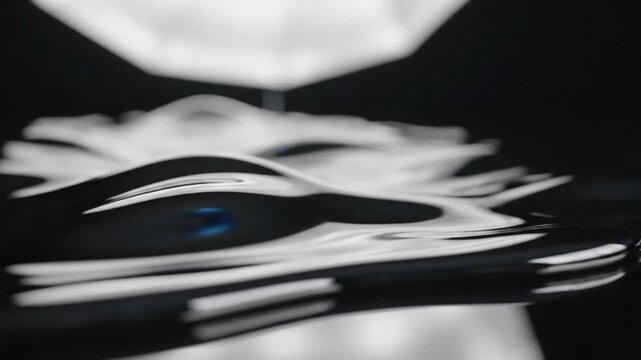 Liquid metal waves flowing freely on a reflective surface creating abstract blurred motion