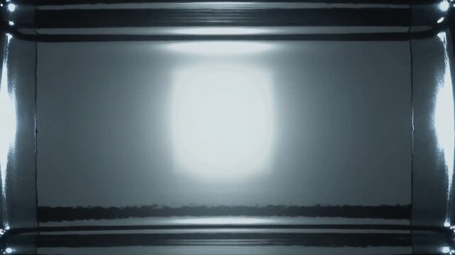 Growing ripples from center impact in reflective tank, overhead light dominating as energy fading