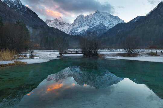 Frozen Sava Dolinka River bordered by snowy mountains in winter, Kranjska Gora, Upper Sava Valley, Slovenia