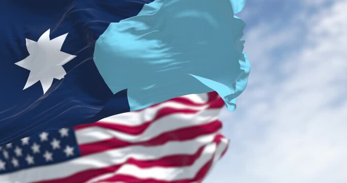 Minnesota and USA flags waving on a clear day