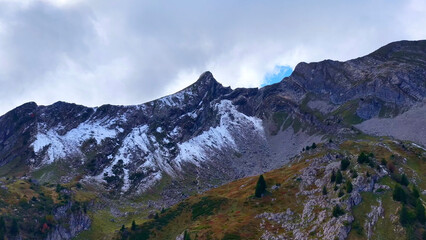 Fototapeta premium 4K Drone View Alpine Peak With Snow And Rocky Slopes