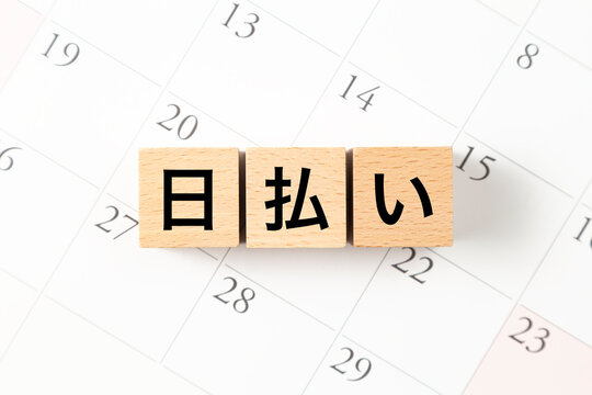 「日払い」と書かれたブロックとカレンダー
