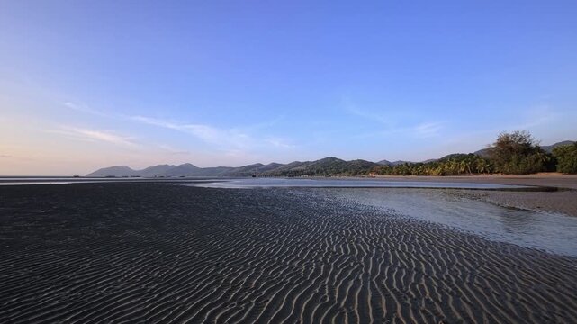 Rippled tidal sand patterns across tropical coastal flats at low tide in Thailand