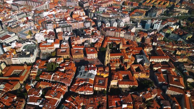 High altitude aerial view of Oviedo city center and Cathedral, bird's eye perspective of red terracotta roofs and historic town square, Asturias, Spain, 4K drone