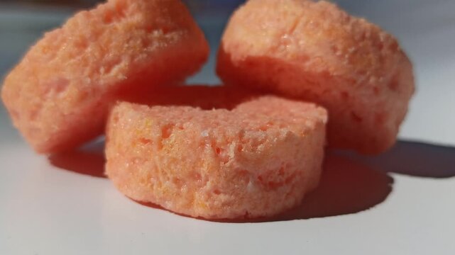 Soft sponge snack with strawberry flavor and pink layers, a sweet treat often found in bakeries and snack stalls with a light texture and fruity aroma