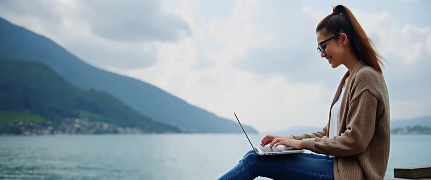 Young woman typing on laptop by urban waterfront, camera slowly pans to reveal scenic city skyline in soft focus, gentle breeze rustles leaves, cinematic and serene atmosphere.
