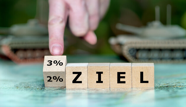 Konzeptbild zu 2% und 3% Ziel: Holzkl&ouml;tze mit Prozentangaben und &bdquo;ZIEL&ldquo;, Hand erh&ouml;ht die Zielmarke. Symbol f&uuml;r NATO-Vorgaben, Verteidigungsausgaben, Budgeterh&ouml;hung und politische Strategie.