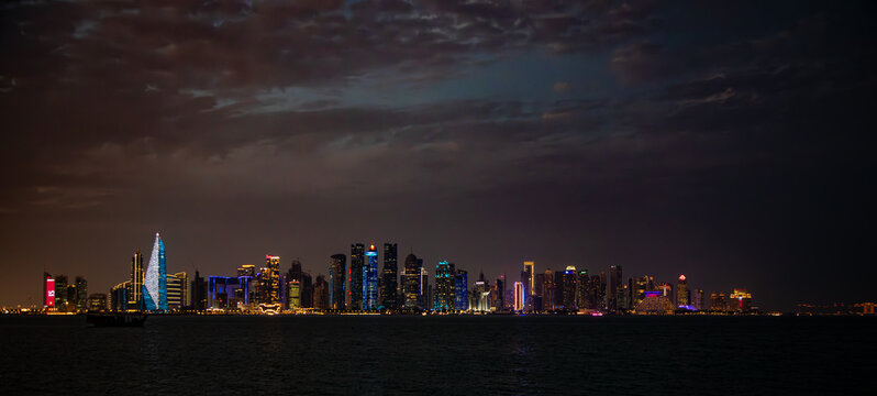 Doha, Qatar&rsquo;s skyline of skyscrapers and harbor at night
