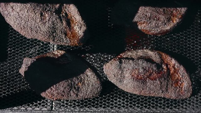 Top down shot of briskets sitting on the grate of a smoker