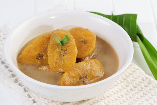 Traditional Indonesian banana kolak dessert with coconut milk and palm sugar syrup served in bowl.