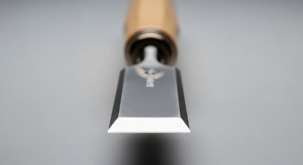 Close-up of a sharp chisel with a wooden handle, showing the shiny blade