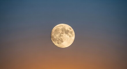 Full moon glows brightly against a gradient sky of orange and blue hues at dusk
