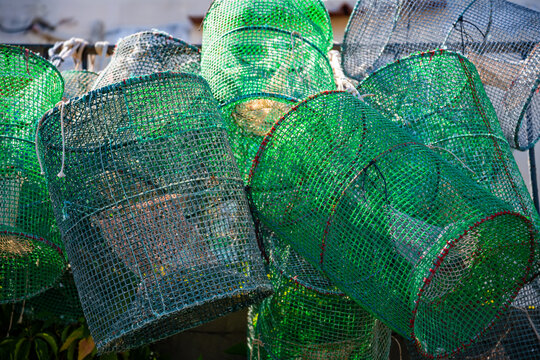 Fishing equipment in the port of Capri (Italy). Green traps and cages for catching crabs and lobsters are stacked up, ready for the next trip. Still life with typical tools used in traditional coastal