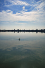 静かな水面に映る空と雲のリフレクション