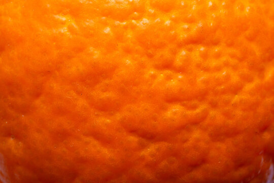 Macro Texture of Fresh Orange Peel Surface Background,Extreme close-up macro shot of a fresh orange skin texture, showing the vibrant orange color and detailed porous surface. Ideal for organic food.