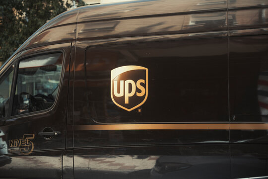 MALAGA - SPAIN, MARCH 2, 2026: Close up of a UPS delivery van with the gold logo on its side parked in a city street.