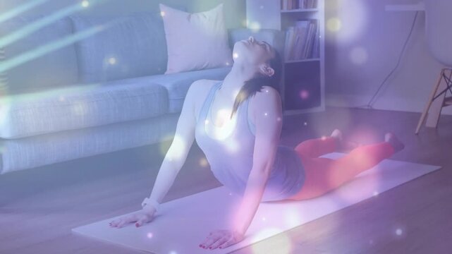 Woman pressing through hands into deep backbend on yoga mat in living room for fitness