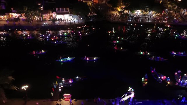 Traditional boats with colorful lanterns sailing on the thu bon river during a festival at night in hoi an, vietnam