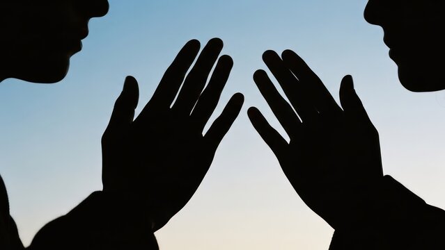 Two silhouettes facing, hands up, perhaps whispering