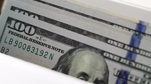 Stack hundred dollar bills in automatic currency counter machine. Success business money processing financial banking automation. High speed cash counting device Benjamin Franklin portrait banknotes