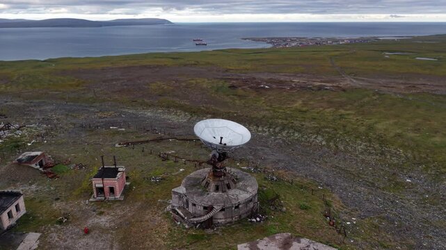 Close view of the parabolic bowl at the abandoned Orbita station in Chukotka near Lavrentiya. Steel framework, concrete base and wild tundra create a rare industrial heritage scene for documentary