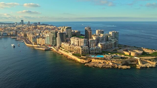 Drone sunset view of buildings in Sliema coastline. Malta. Mediterranean sea