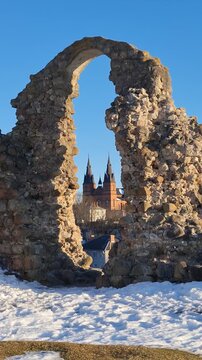 Lettland, Latgale &ndash; Rēzekne. Die Ruinen der alten Burg mit einer alten Steinmauer, im Hintergrund eine Kirche. Historischer Ort in der Stadt Rēzekne.
