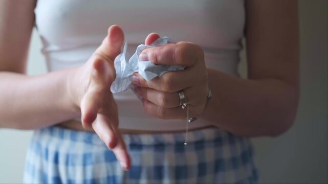 Close up of hands crumpling white notebook paper relieving stress and releasing negative thoughts through mindful action