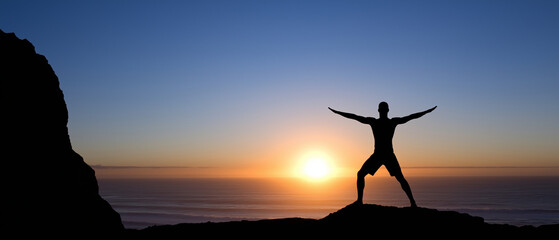 Fototapeta premium Silhouette man practicing yoga on cliff at sunrise over ocean, freedom and mindfulness concept
