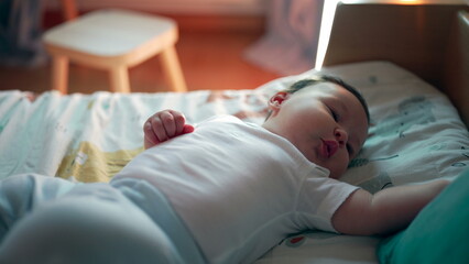 Baby lying on bed stretching, playful movements, early development, comfort in home setting, relaxed and curious, childhood growth, infant enjoying cozy atmosphere
