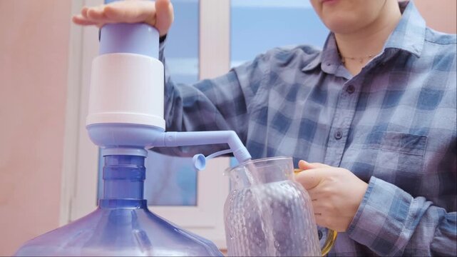Woman hands operating manual water pump preparing drinking water promoting sustainable lifestyle safe clean water at home