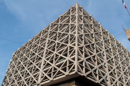 Guadalajara, Mexico - November 8 2025: Architectural detail of a concrete building in Guadalajara city center. Its intricate geometric lattice facade forms a striking pattern under a bright blue sky