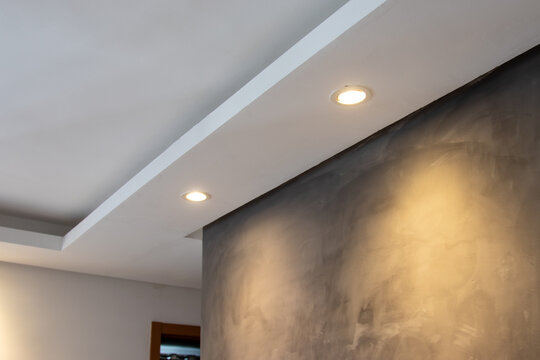 Detail of recessed ceiling lighting with LED spotlights lit in a residential interior. 