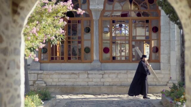 Orthodox christian monk in traditional black robes walking at the Mount Athos monastery in Greece