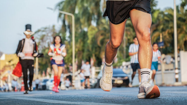Marathon runners in action with people in fancy dress costumes in the background