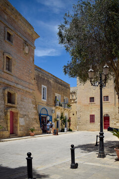 Quaint square with traditional stone buildings in Mdina, Malta