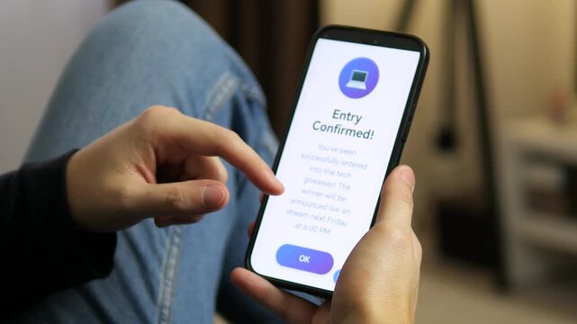 User finger tapping the screen to confirm participation in a prize draw. High-quality clip of mobile UI interaction, successful notification, and digital marketing engagement via a modern smartphone.