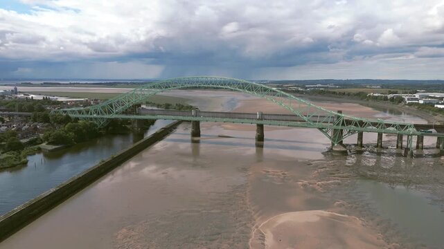 Liverpool, Merseyside, UK, September 09, 2025; aerial 4K video footage of the Silver Jubilee Bridge and Britannia Railway Viaduct over the River Mersey and Manchester Ship Canal, Runcorn, Merseyside
