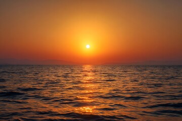 The sun setting over the tranquil ocean, casting a warm glow