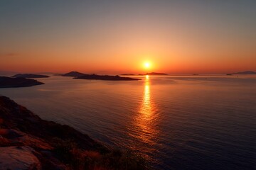 Obraz premium A mesmerizing sunset view over the ocean with the sun reflecting on the water, highlighting the islands in silhouette 