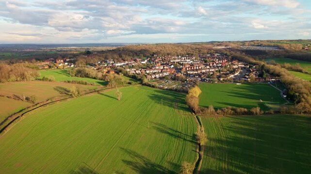 Aerial view of Baddesley Ensor's houses nestled beside vibrant green fields, a picturesque blend of rural charm and village life, Baddesley Ensor, Atherstone, United Kingdom.